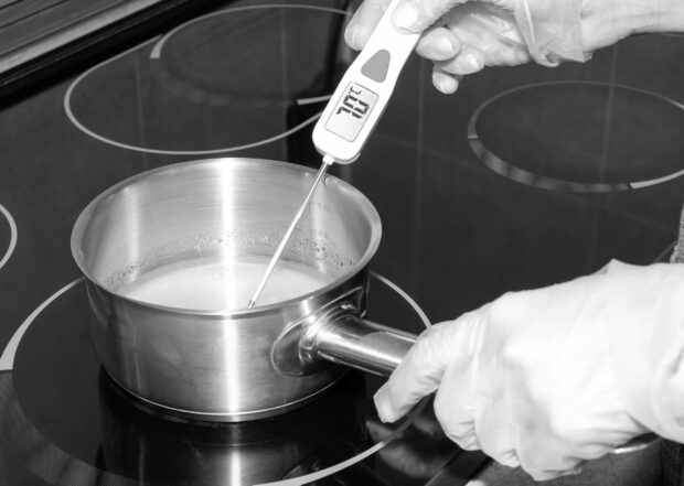The temperature of the boiling syrup in the pan is measured with an electronic thermometer.
